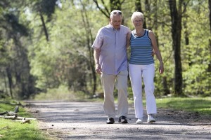 Lovely senior couple strolling through the park arm in arm